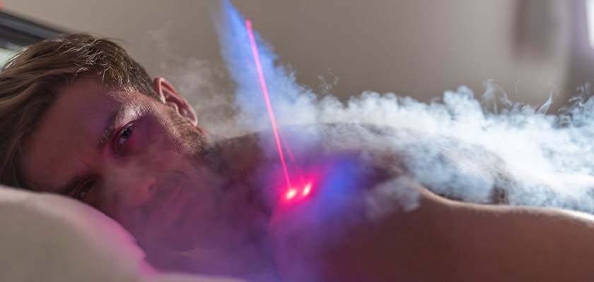 Eine Person liegt entspannt, umgeben von Rauch und buntem Licht, wirkt nachdenklich.